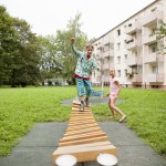 2 Kinder spielen zusammen auf dem Spielplatz vor den Mietwohnungen