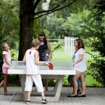 5 Kinder spielen zusammen Tischtennis