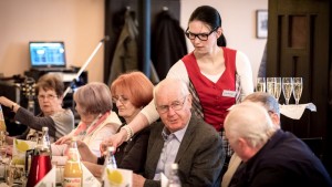 Kellnerin serviert Sektgläser auf der WOGETRA Veranstaltung 50 Jahre Wohndauer