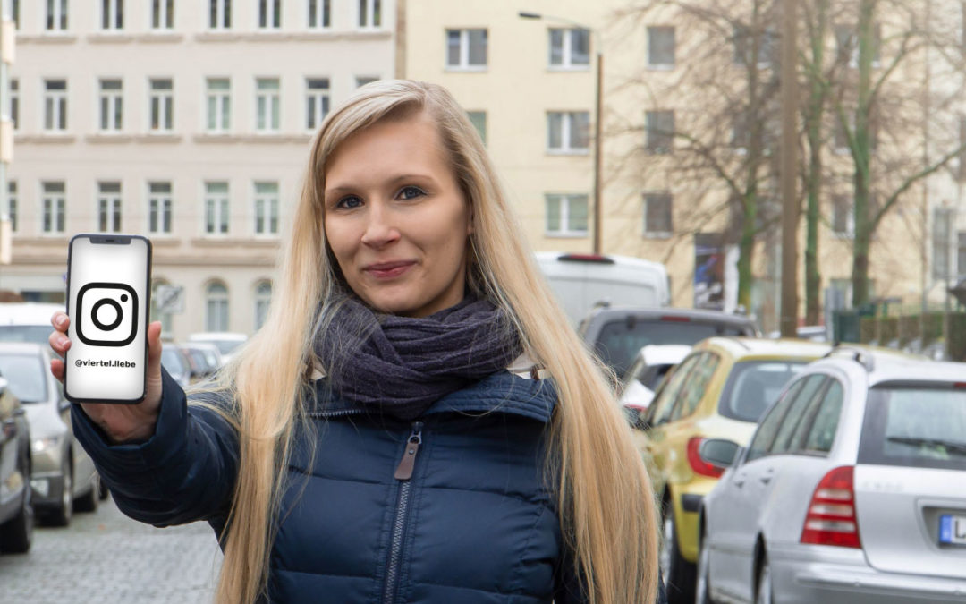 Junge Frau steht auf einer Straße und hält Smartphone in die Kamera
