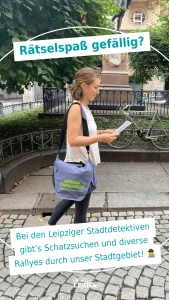 Junge Frau schaut auf eine Karte der Leipziger Stadtdedektive