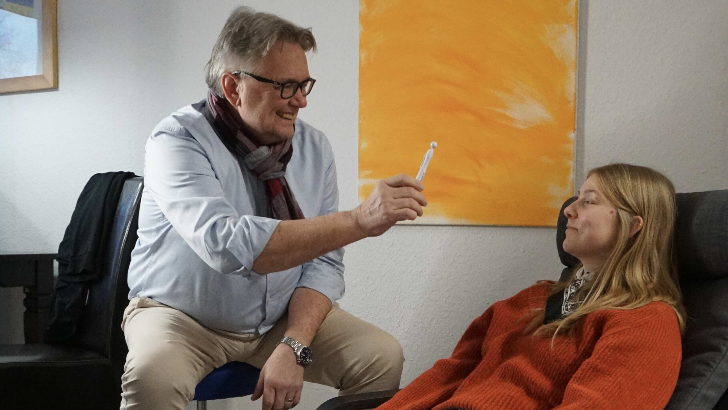 Ein Therapeut führt eine Sitzung zur energetischen Harmonisierung mit einer Patientin in der homöopathischen Praxis in Connewitz durch.